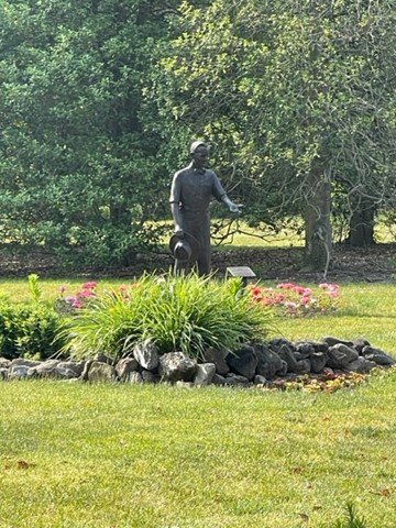 This picture shows a statue of a gentleman in the gardens at the park.