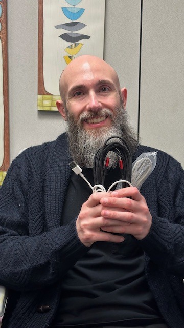 This is a picture of Ben with many device cords