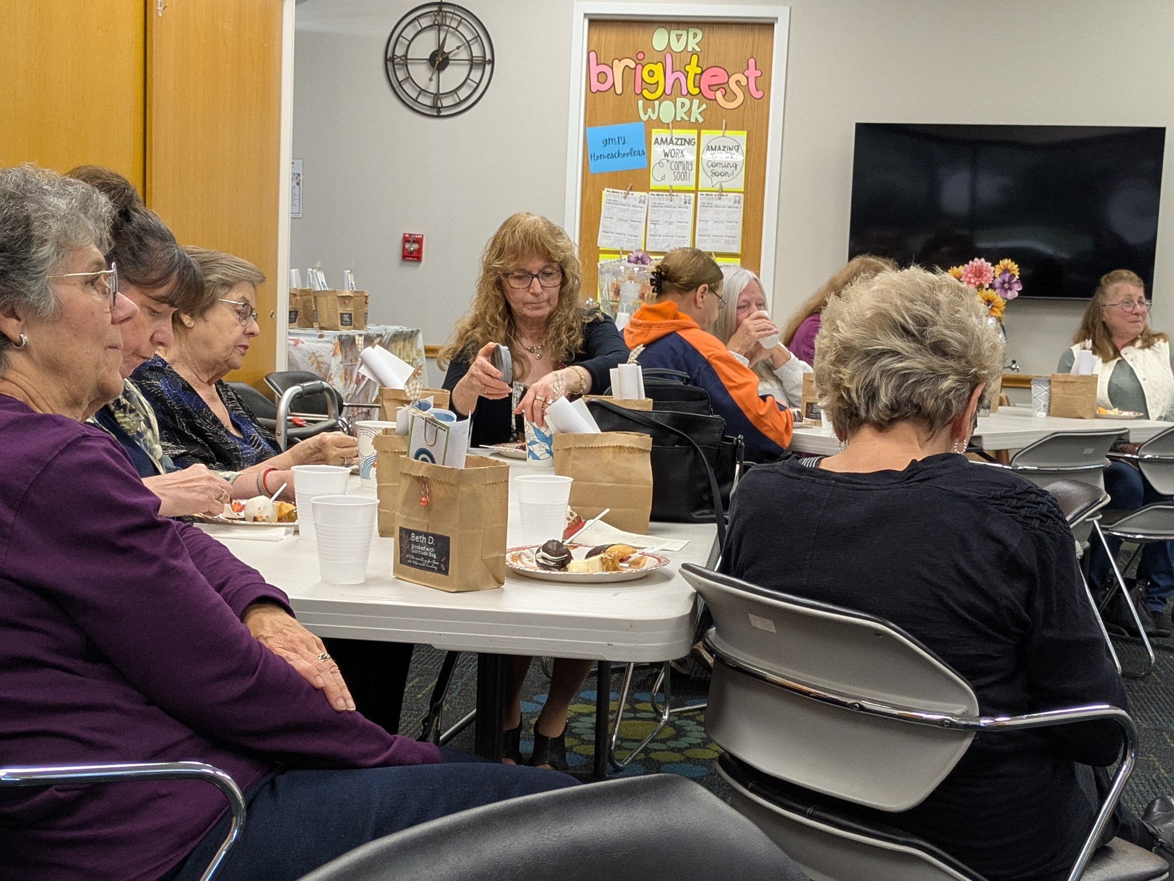 Volunteers sit at tables and enjoy a Loretta Lynn presentation