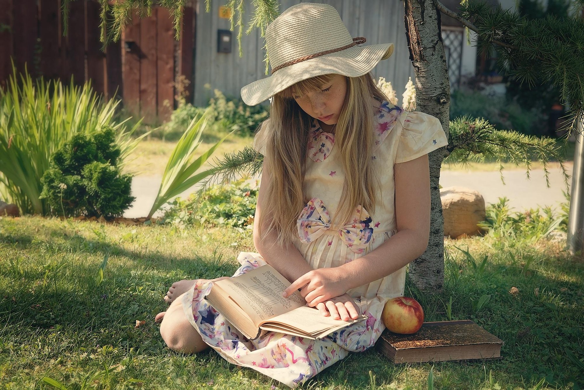 child reading a book outdoors