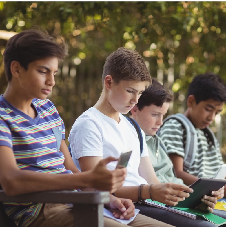 Teens reading outside on their devices